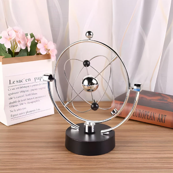 Pêndulo orbital decorativo cinético AstroZen Nomanni, ideal para escritório e home office, com design sofisticado e movimento contínuo elegante.